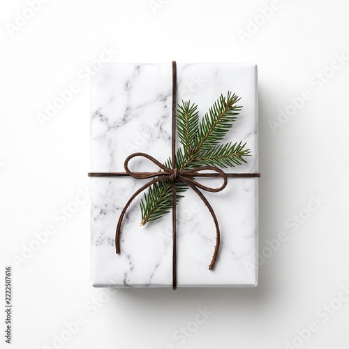 Gift wrapped in marble paper with pine branch and brown twine string.