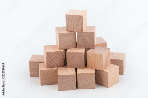 Many natural wood blocks stacked together on a white background
