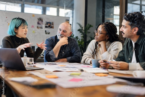 Creative professionals brainstorming ideas together in a collaborative boardroom