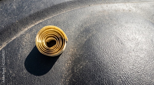 Wood shaving curl resting on a textured black surface with copy space