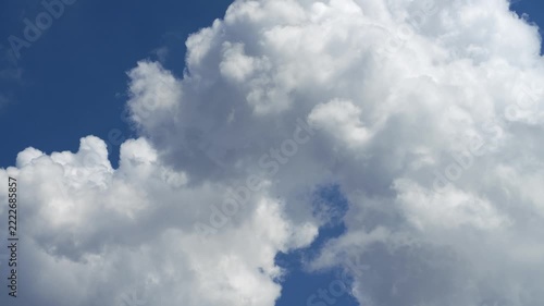 Cumulus clouds moves in the blue sky. The background of light and heavy calm clouds changes shape in cloudy space.