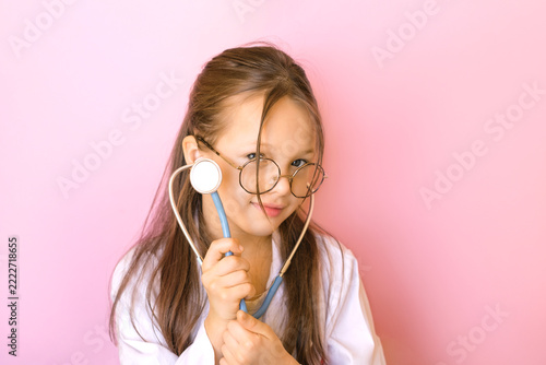 A child in the profession of a pediatrician holds a stethoscope in their hand. Pediatrics and pediatric cardiology. Diseases and heart defects.