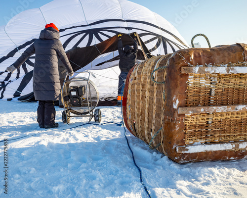 Balloon crew sets up basket in cold, sunny winter day