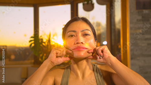 Fotografie CLOSE UP, PORTRAIT Filipina woman doing facial yoga and massage for rejuvenation