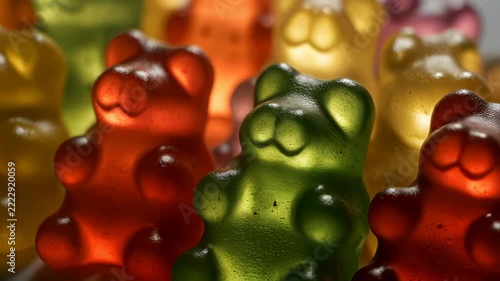 Group of vibrant colorful gummy bear candies glowing with translucent texture under dramatic soft lighting 4K Generative AI