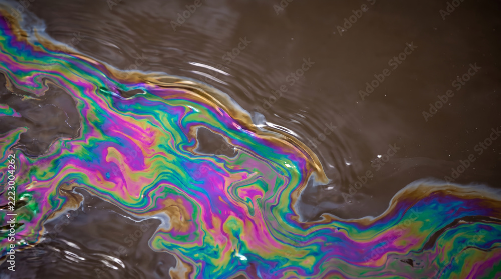 Fototapeta premium Abstract oil slick texture creates colorful environmental crisis background with swirling iridescent pattern. Global climate change drought disaster earth nature ecology abstract ground surface