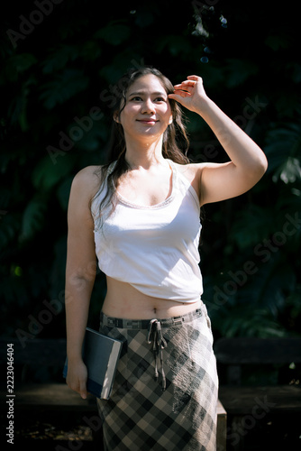 Bright Smiling Young Woman Standing Outdoors During Sunny Day Holding Book