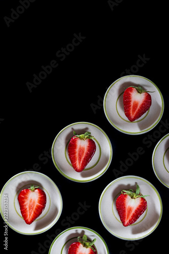 Top view of ripe strawberry fruits served on small cups.