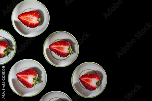 Top view of ripe strawberry fruits served on small cups.