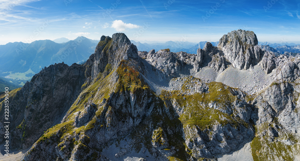 Fototapeta premium Scenic view of mountain peak Hochturm in Hochschwab region, Styria, Austria. Steep rocky cliffs covered in deciduous trees in vibrant autumn colors. Wanderlust Austrian Alps.