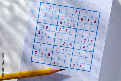 Pencil on sudoku puzzle in sunlight