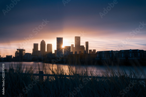 The Sun rising between the buildings of Canary Wharf, London. 