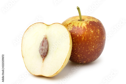 Fresh jujube cut in half, revealing the flesh and pit, placed next to a whole jujube. isolated on white backgroung 