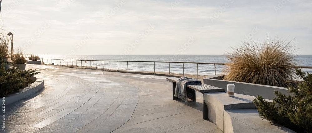 Fototapeta premium Modern Seaside Promenade With Coastal Bench And Ocean View During Golden Hour Winter Season Photo