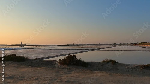Golden sunset over tranquil salt pans near Trapani, Italy