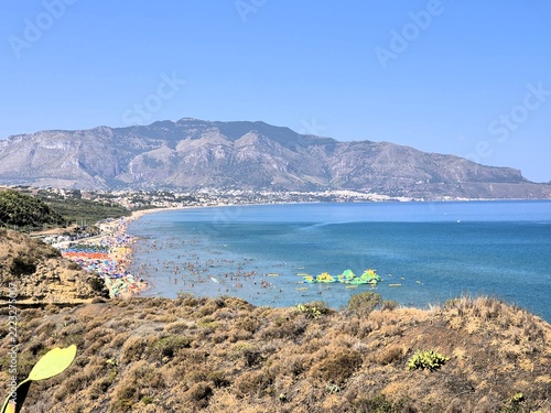  Sunny coastal destination featuring clear waters, beach activities and surrounding mountains. Vibrant summer landscape representing tourism and leisure in southern Europe.
