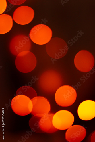 Abstract orange and golden bokeh lights glowing against a dark background creating a warm atmosphere.