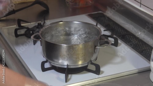 白玉を茹でる女性