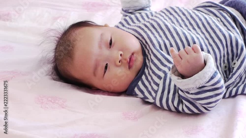 タイムラプスで撮影した家のベッドの上にいる可愛い新生児の赤ちゃんの遊ぶ様子
