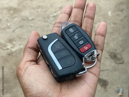 Person Holding Black Car Key Fob Remote Control Open Palm