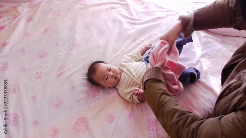 タイムラプスで撮影したベッドの上にいる可愛い新生児の赤ちゃんの服替えの様子