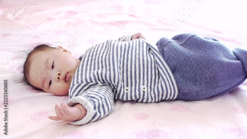 タイムラプスで撮影した家のベッドの上にいる可愛い新生児の赤ちゃんの遊ぶ様子