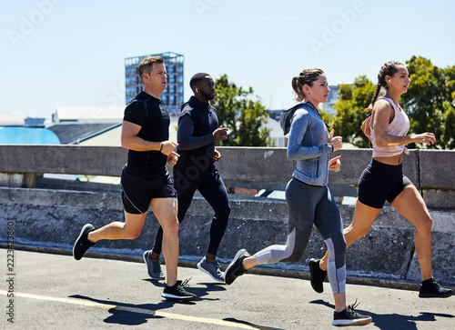 Action, fitness and people running in city, marathon training for cardio and workout outdoor. Sport, athlete group or runner club with endurance, energy and exercise for race prep with practice