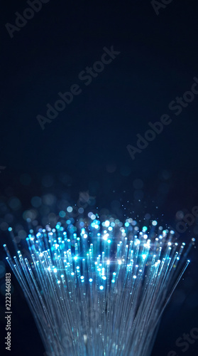 Fiber optic cables transmitting data with blue light on dark background. Cybersecurity and digital network infrastructure. Secure data transmission and telecommunications technology.