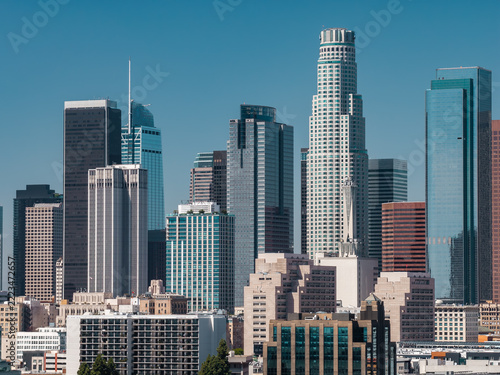 Downtown Los Angeles skyline features modern highrise towers including US Bank Tower, Aon Center, and Wilshire Grand Center on a bright sunny day in California.