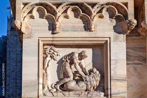 Fotografie A relief depicting the biblical scene of Samson and the Lion, located on the façade of the Cathedral of Milan (Duomo di Milano) in Italy