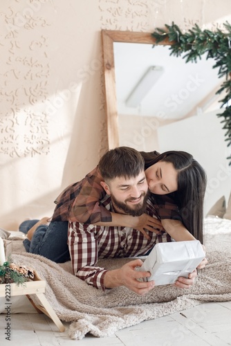 Romantic couple laying on a blanket with a present box