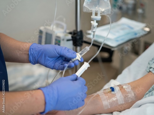 infusion pump tubing setup closeup Healthcare professional adjusting IV drip for patient in hospital setting