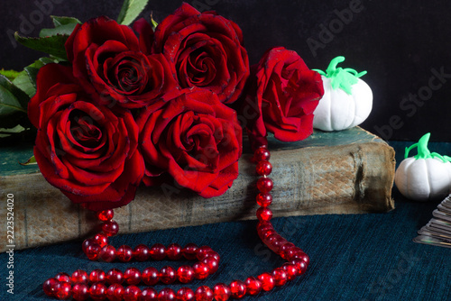 still life with red roses, burning candles, old fashioned books, books and flowers. still life, romantic, love, romantic concept. valentines