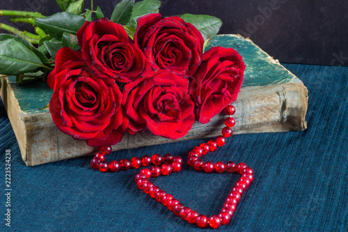 red roses and heart on a wooden background