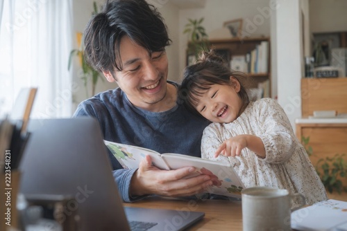 Joyful father and daughter sharing a story at home together