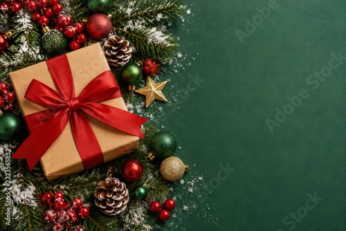 Christmas Gift Box with Red Ribbon and Festive Decorations on Green Background
