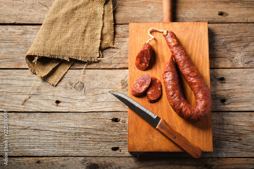 Spanish Chorizo Rests on a Wooden Board With Knife and Slices Nearby