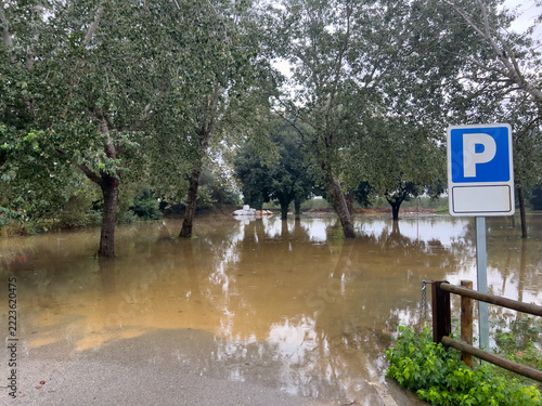 Floodwater covering parking area and trees in Gualta, Catalonia