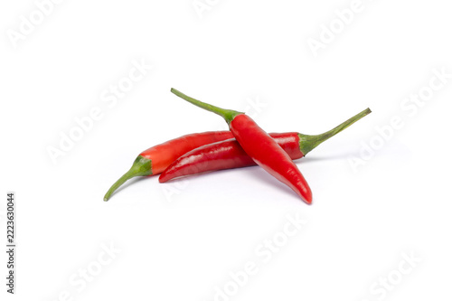 Three red chili peppers crossed on white background