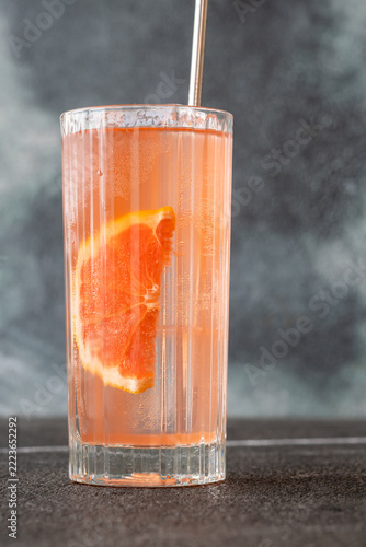 Refreshing pink Paloma cocktail with grapefruit ice bubbles and modern metal straw