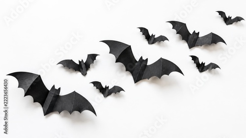 Handmade black paper bat decorations arranged diagonally on a clean white background