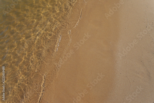 Clear seawater and sand on the shore.