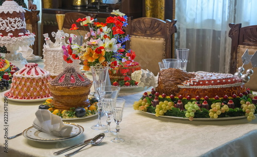 A luxurious dessert table with cakes and fruits.