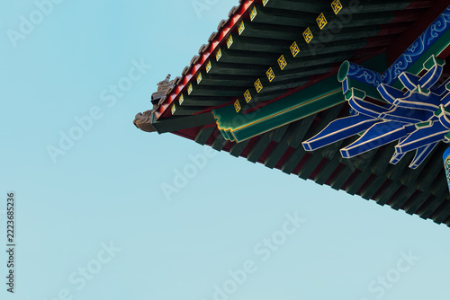 A fragment of traditional Chinese architecture is a decorative roof cornice with elements of douxiong coupling and bright blue—green-red painting