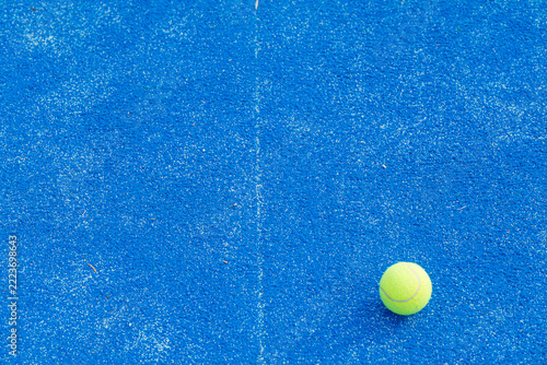 Yellow ball on blue padel court with faded white line The Concept of athletic preparation
