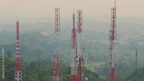 Aerial view of television broadcasting station with tall communication towers set against a backdrop of lush green hills in Samarinda, East Kalimantan, Indonesia.