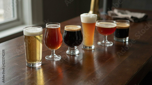 Craft beer flight with variety of ale and stout glasses arranged on a
