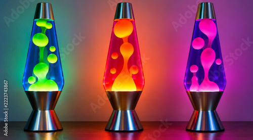 Three colorful lava lamps glowing with liquid wax motion on a table