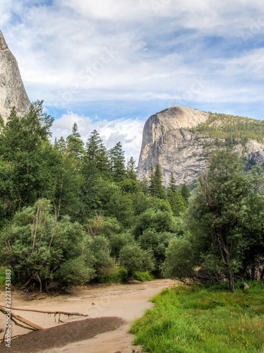 Yosemite Valley in Yosemite National Park, California, USA, with granite cliffs rising above pine forest and a sandy trail in summer