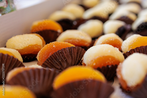 Filled dried apricot treats arranged in brown paper cups